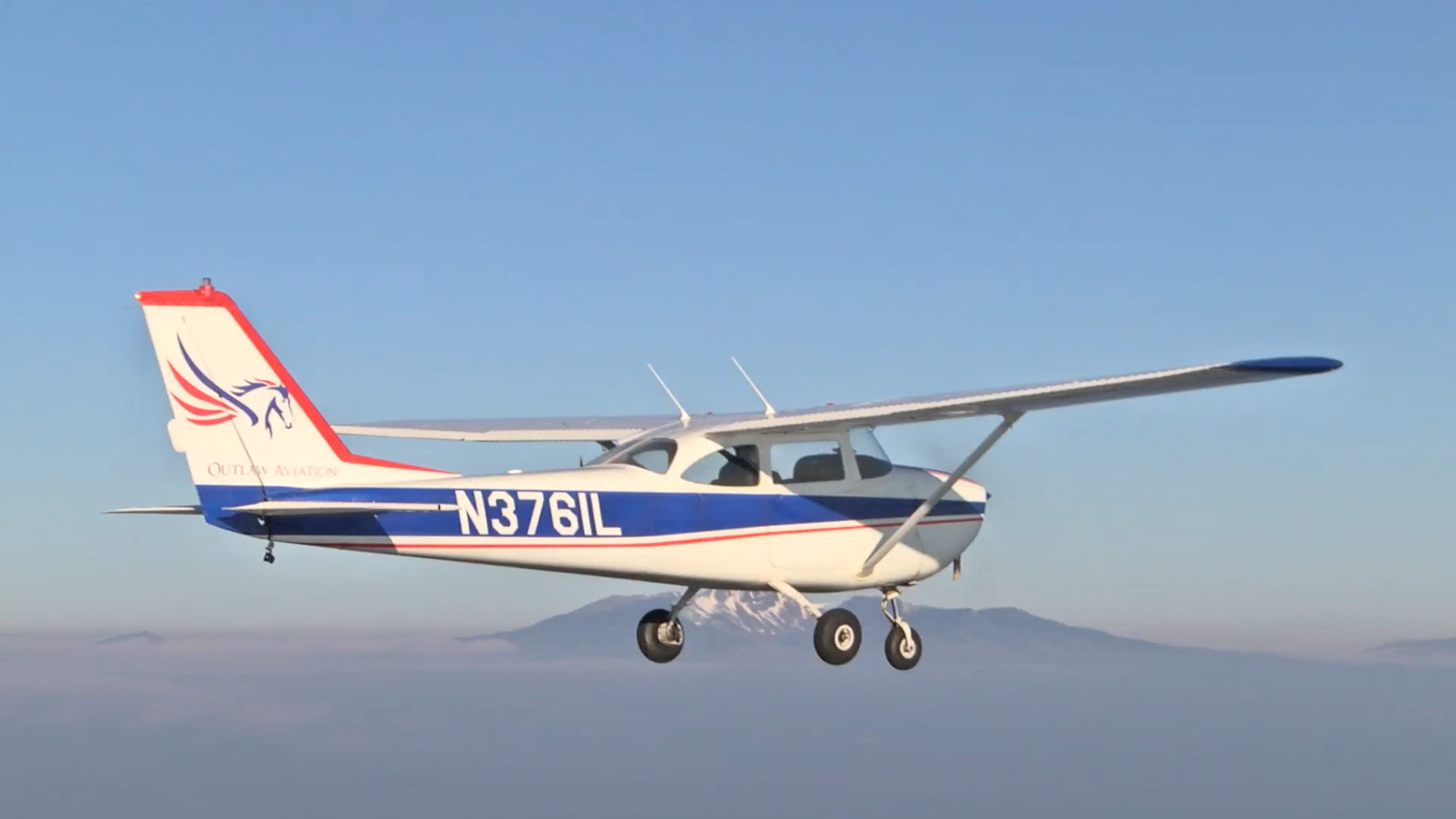 A small aircraft above the snow-capped Three Sisters peaks of the Oregon Cascades near Sisters Eagle Airport
